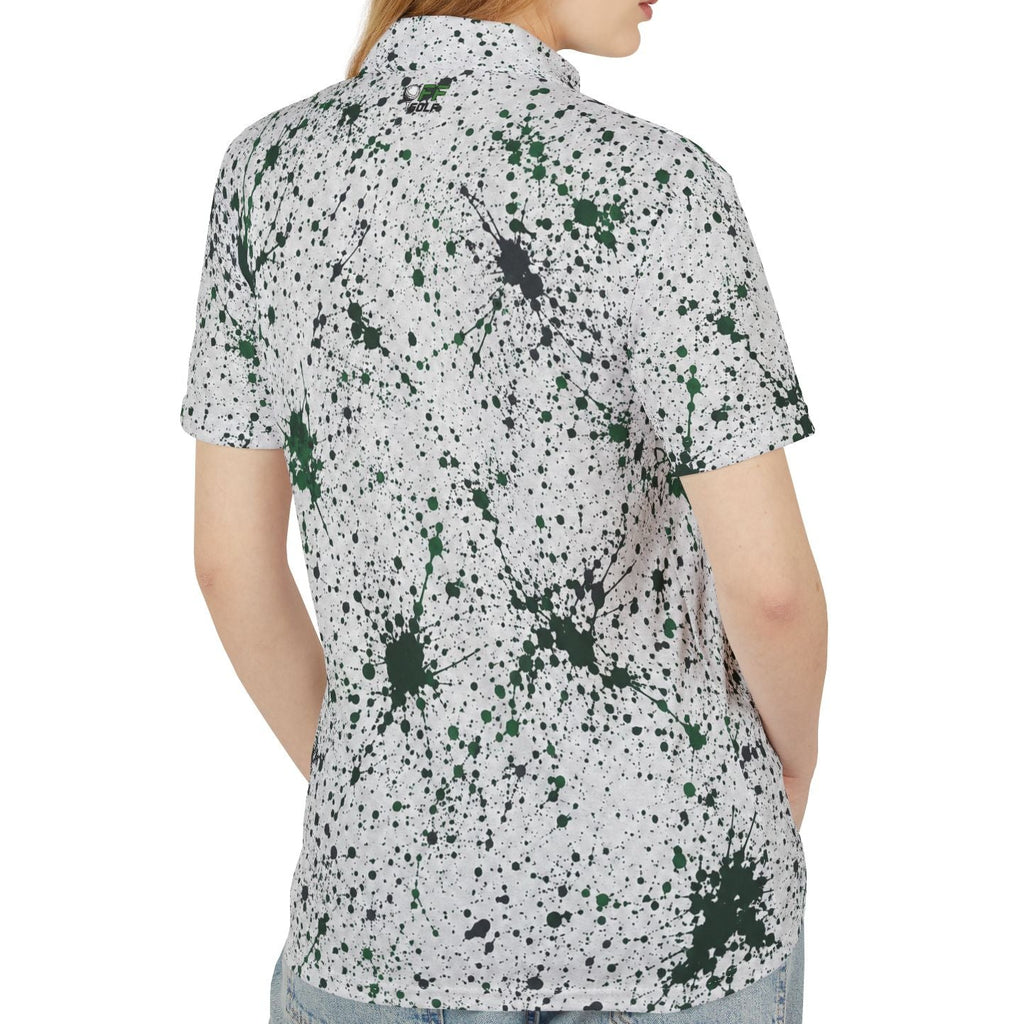 A woman shown from the back wearing a short-sleeve button-up shirt with a white base and dark green and black paint splatter pattern, paired with light blue jeans against a plain white background.