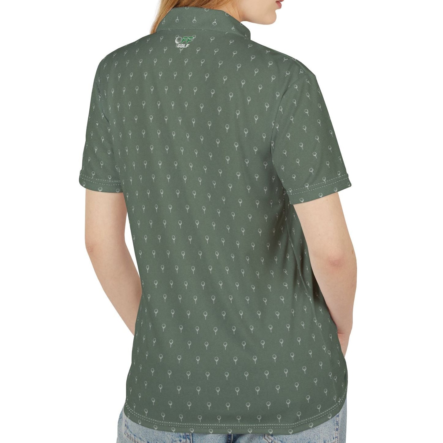 A woman with red hair is shown from the back wearing a short-sleeve polo shirt with a repeating white anchor pattern on a dark green base, paired with blue jeans against a plain white background.