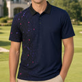A man wearing a navy blue short-sleeve polo shirt with a black collar and a subtle multicolor geometric pattern on the front, standing on a golf course with a house in the background.