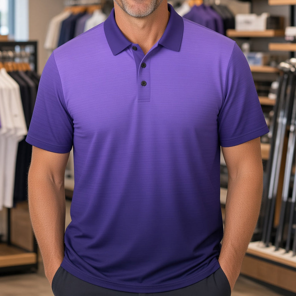 A smiling man wearing a purple short-sleeve polo shirt stands inside a retail store with shelves and clothing racks visible in the background.