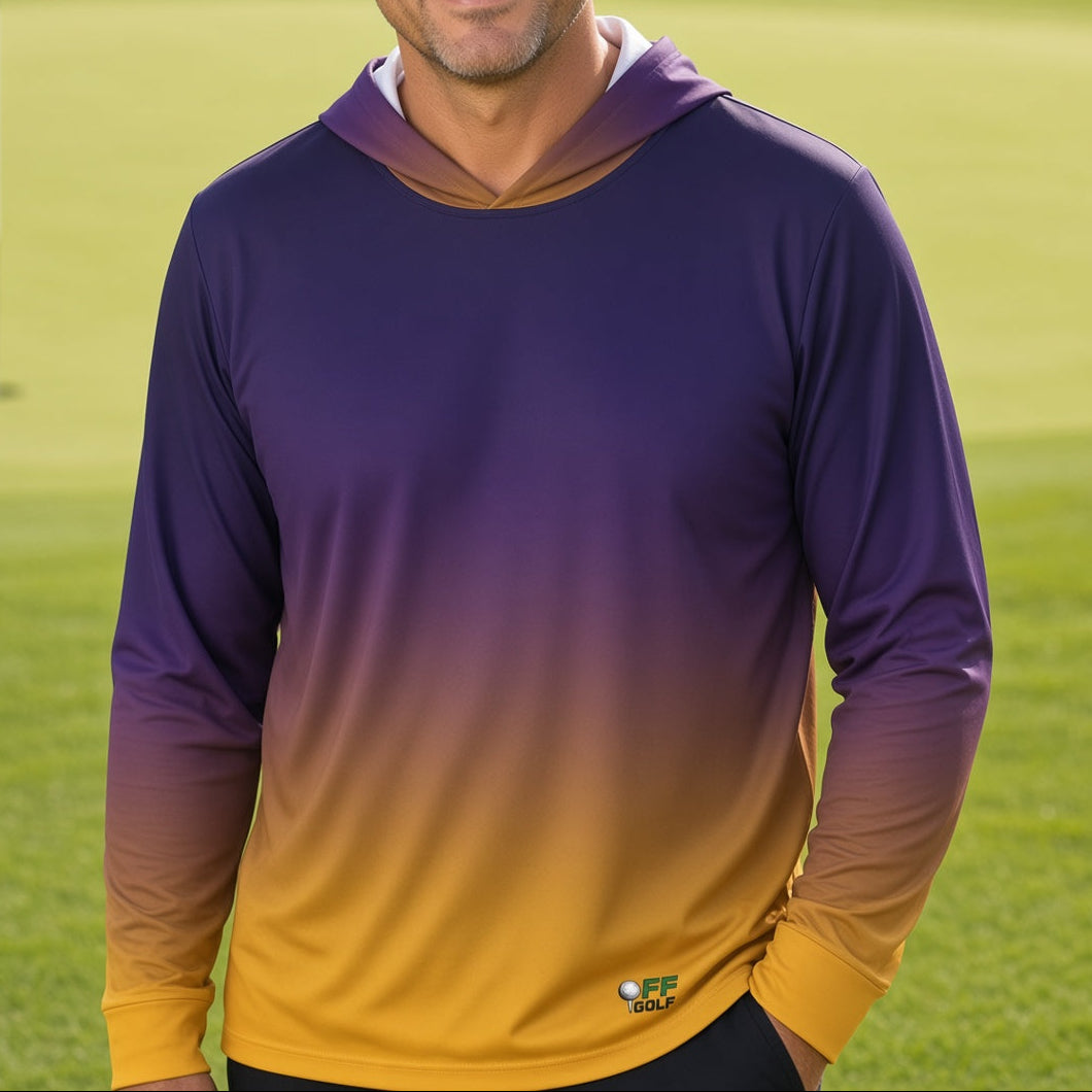 A man standing on a golf course wearing a purple and yellow gradient long-sleeve hooded shirt.