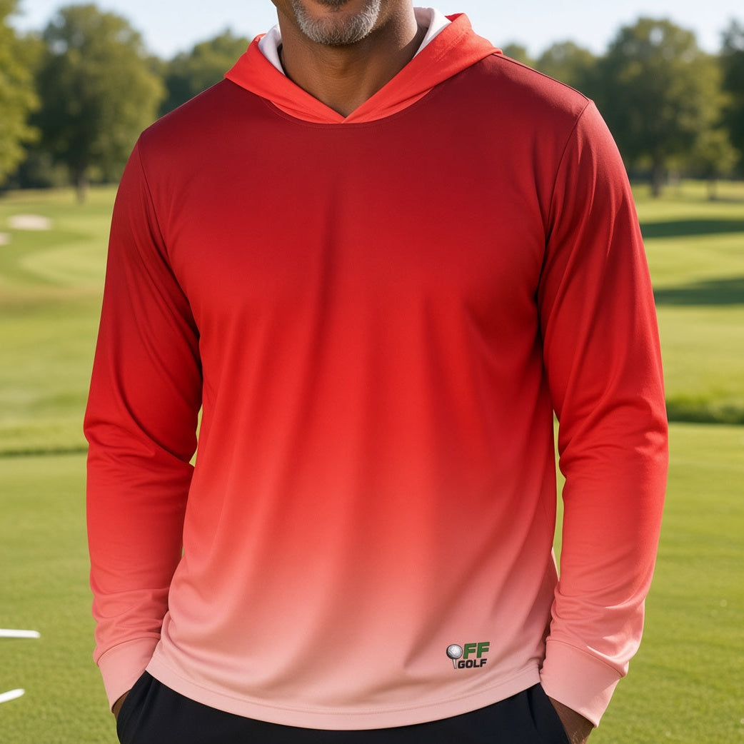 A smiling man wearing a red-to-pink gradient long-sleeve hooded shirt stands on a golf course with trees and grass in the background.