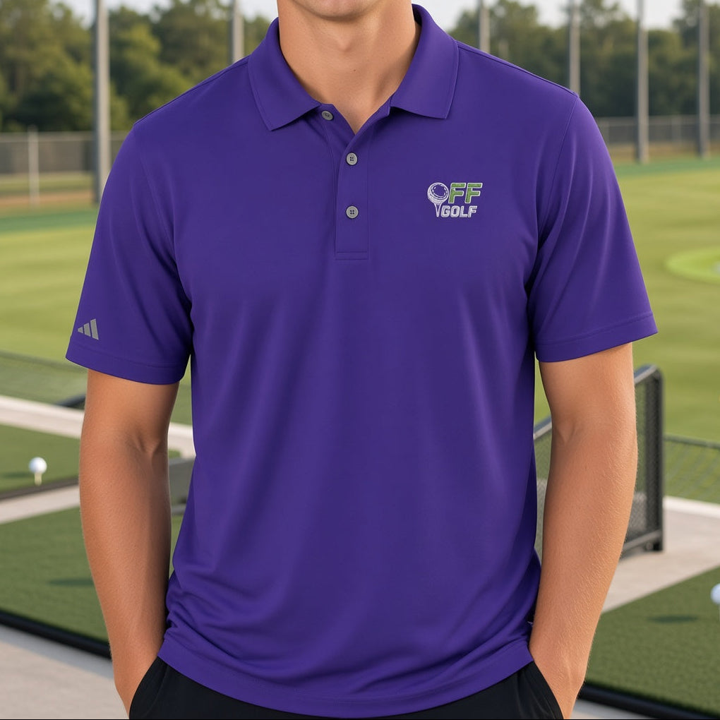 A smiling young man wearing a purple polo shirt with a white and green 'Vessel' golf logo on the left chest and an Adidas logo on the sleeve, standing on a golf driving range with green grass and netting in the background.