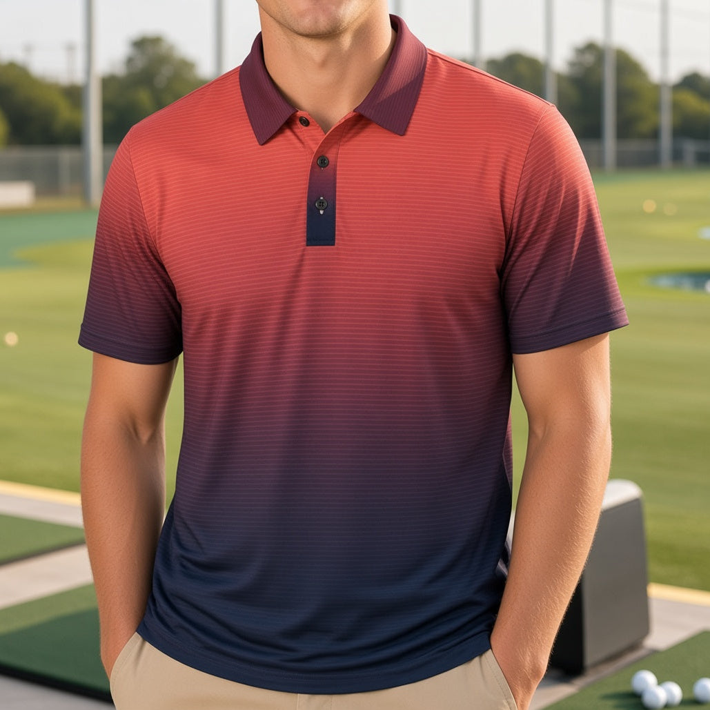 A smiling man wearing a short-sleeve polo shirt with a red-to-blue gradient, standing on a golf driving range with golf balls and hitting mats in the background.
