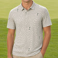A smiling man stands on a golf course wearing a short-sleeve polo shirt with a light beige and white topographic contour pattern and khaki pants.