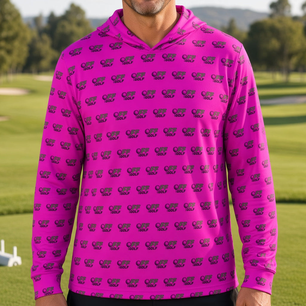 A man wearing a bright pink long-sleeve hoodie with a repeating dark purple elephant print, standing on a blurred golf course background.