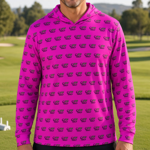 A man wearing a bright pink long-sleeve hoodie with a repeating dark purple elephant print, standing on a blurred golf course background.