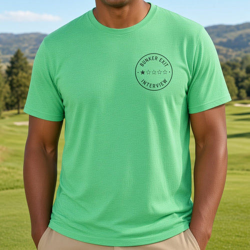 A smiling man wearing a bright green t-shirt with a circular 'Summer Club Intervention' logo on the left chest, standing on a sunny golf course with green grass, trees, and hills under a blue sky.