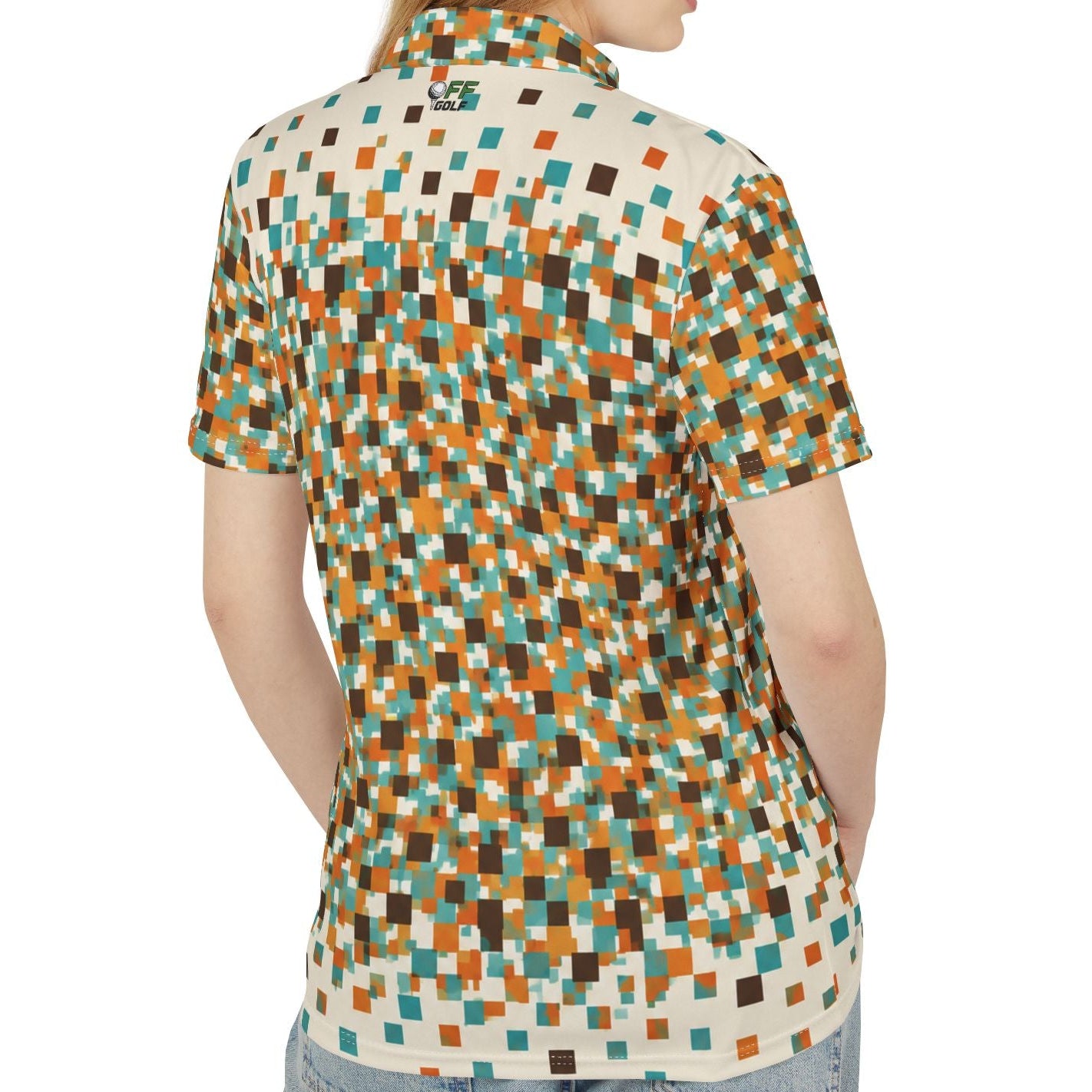 A woman shown from the back wearing a short-sleeve collared button-up shirt with a multicolor pixelated geometric pattern in orange, teal, brown, and cream, paired with light blue jeans against a plain white background.
