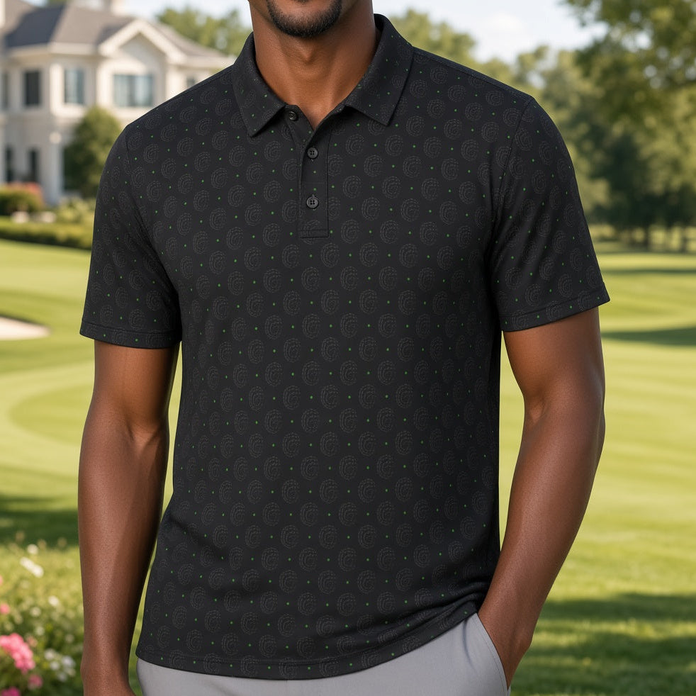 A smiling man wearing a black short-sleeve polo shirt with a subtle repeating geometric pattern, standing on a manicured golf course with a large house in the background.