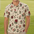 A smiling man stands on a golf course wearing a short-sleeve button-up shirt with a cream base and an allover floral and golf-themed print featuring red roses, green leaves, golf balls, and clubs, paired with khaki pants.